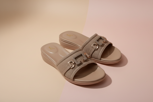 Pair of beige sandals on a white tiled floor