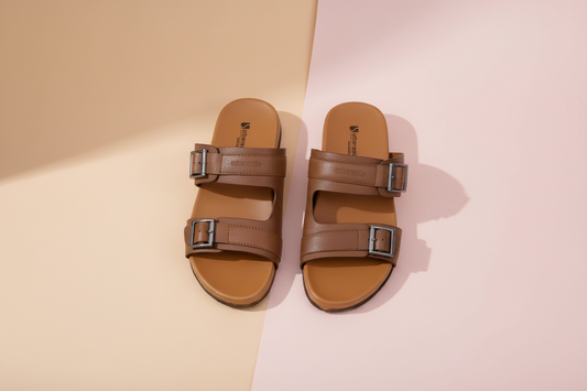 Pair of brown sandals with buckles on a white background