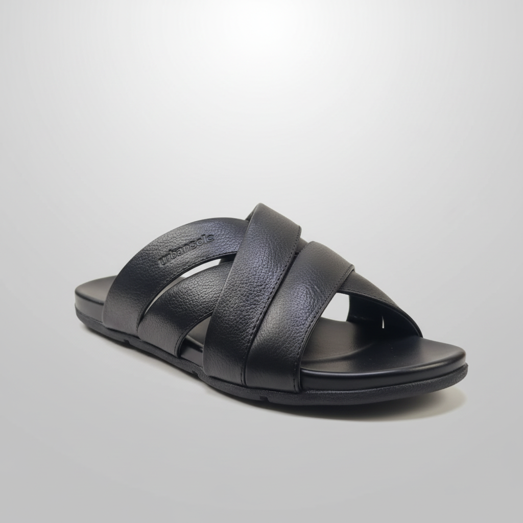 Black sandal with criss-cross straps on a light gray background