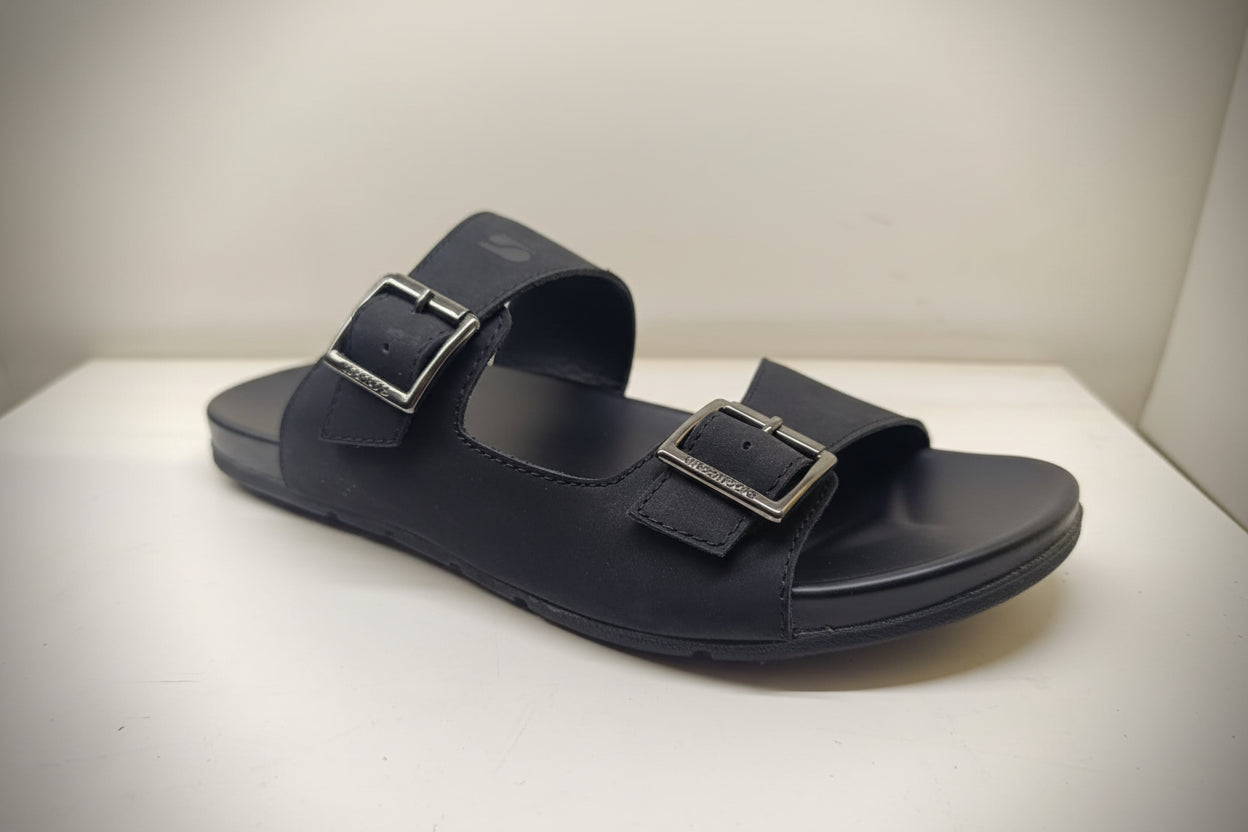 Black sandal with buckles on a white surface