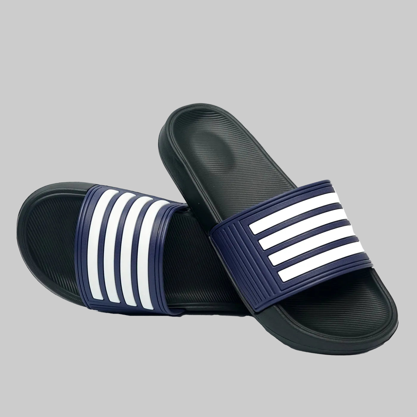 Pair of navy blue slides with white stripes on a white background