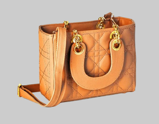 Tan quilted handbag with gold hardware on a white background