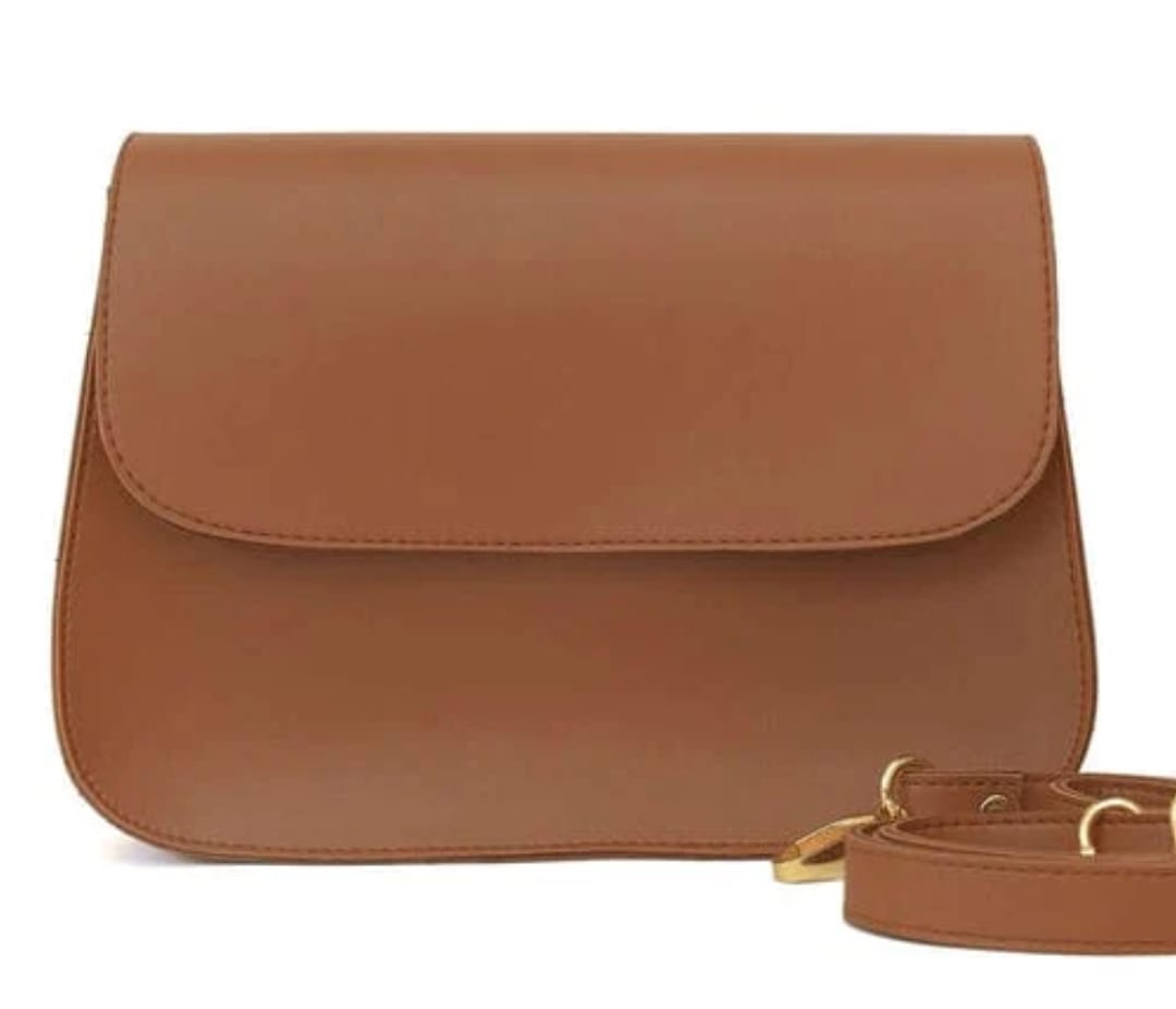 Brown leather handbag with a strap on a white background