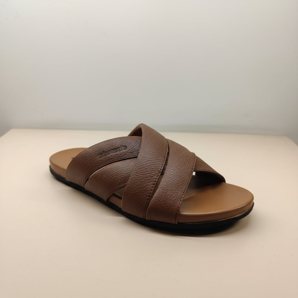 Brown sandal with criss-cross straps on a light background