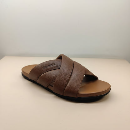Brown sandal with criss-cross straps on a light background