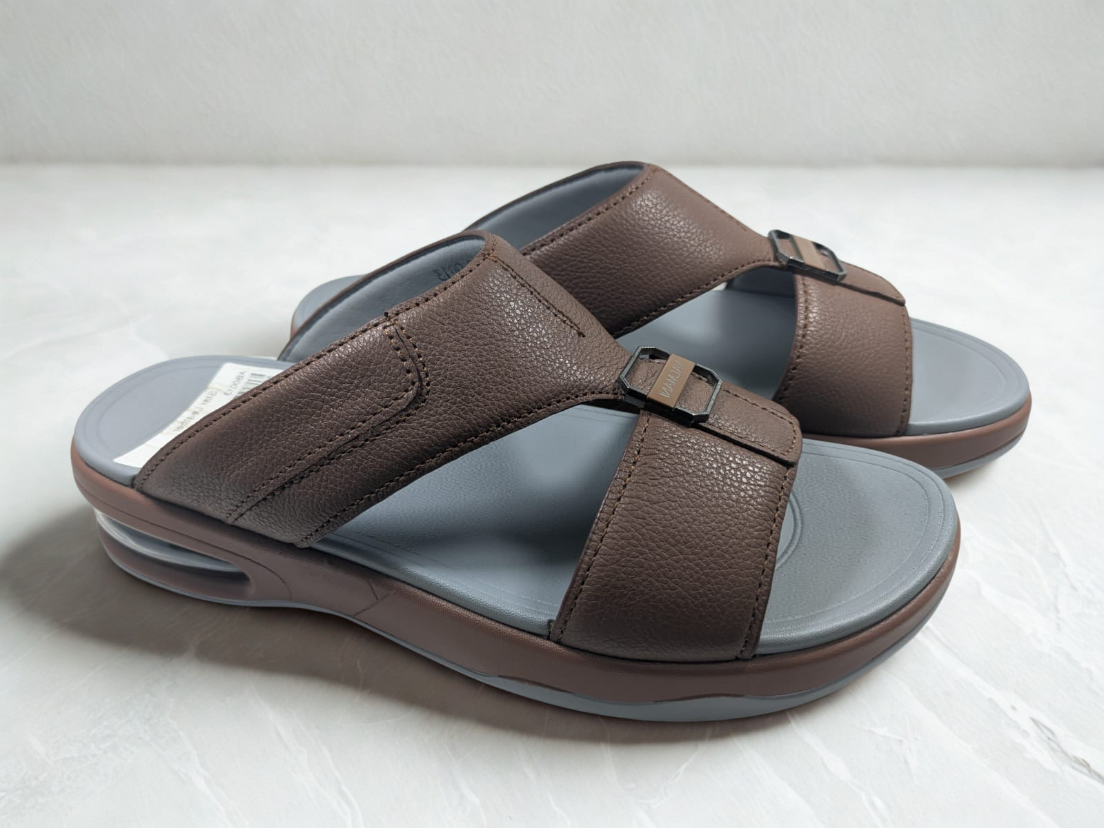 Brown sandals with gray soles on a white background