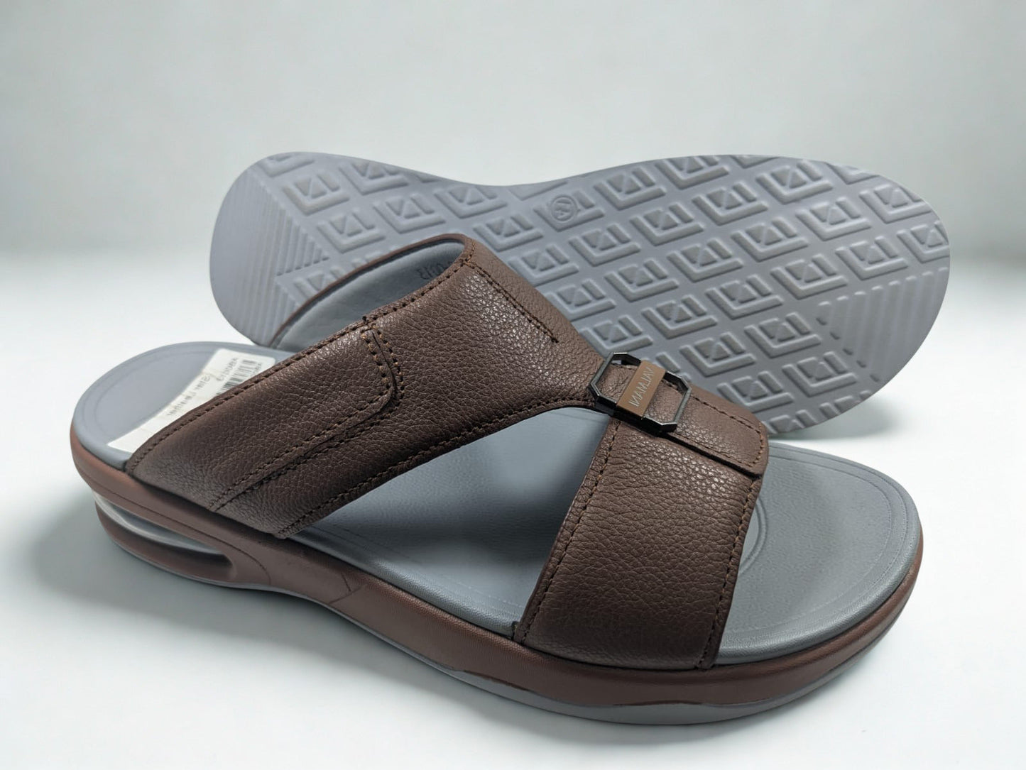 Brown sandal with gray sole on a light gray background