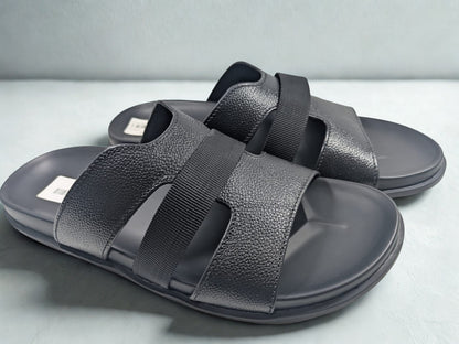 Pair of gray sandals with black straps on a light gray background