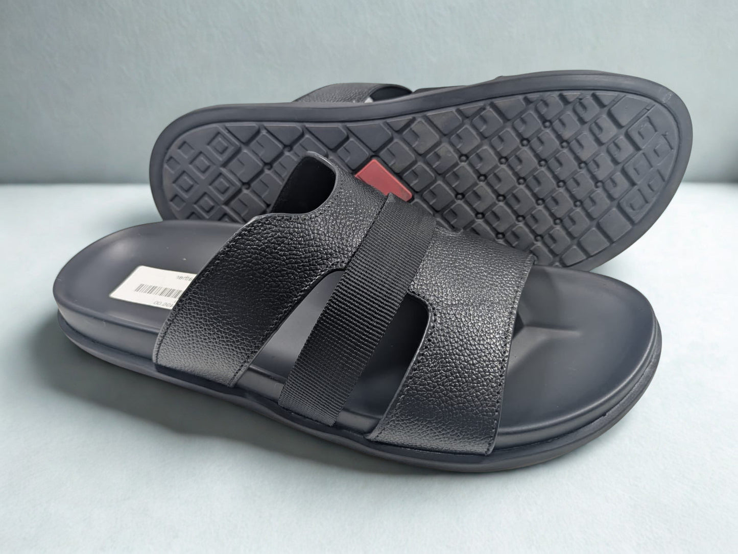 Black sandals with velcro straps on a light gray background