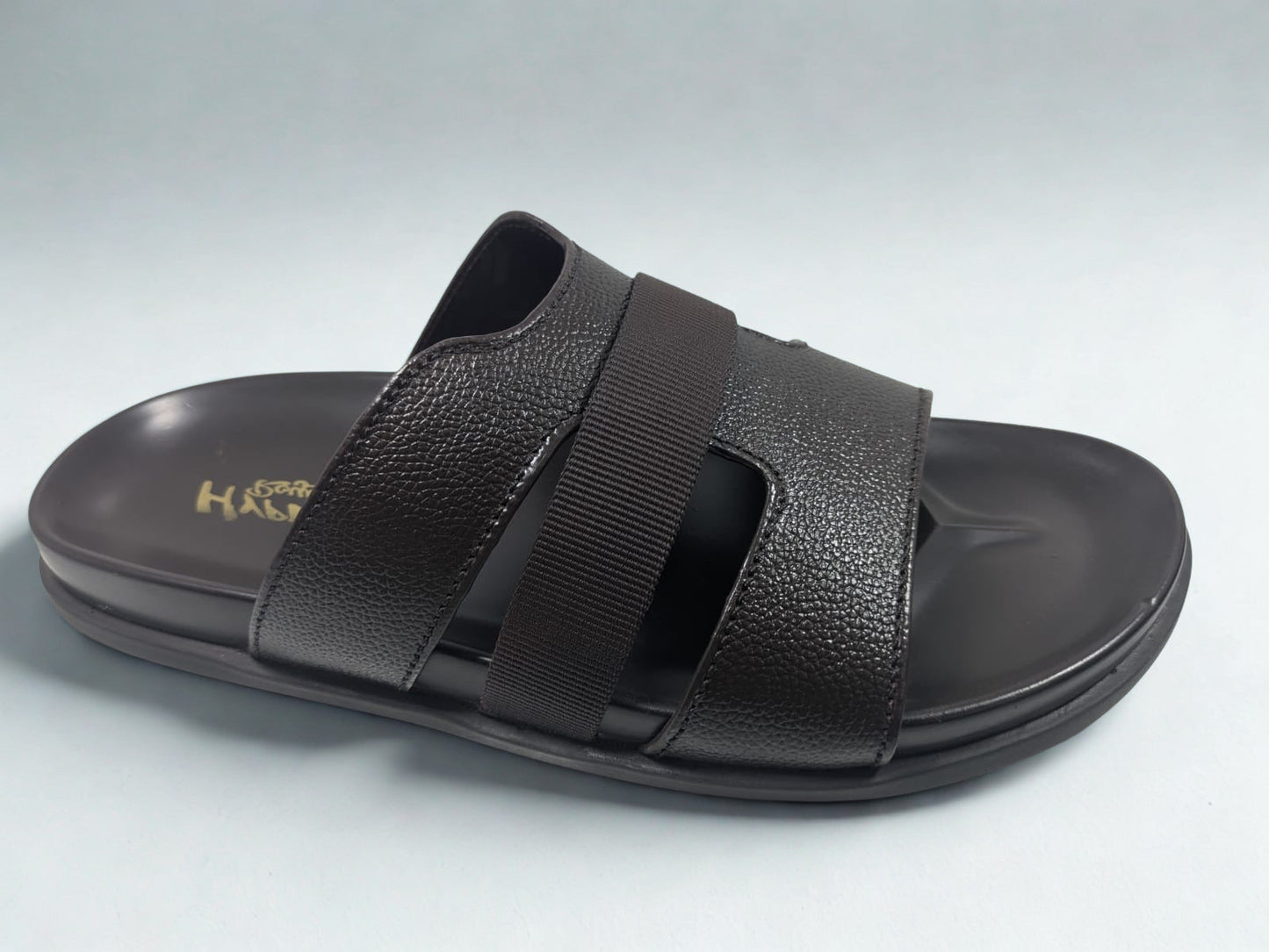 Black sandal with strap design on a light gray background