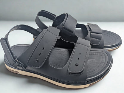 Pair of gray sandals with multiple straps on a light gray background