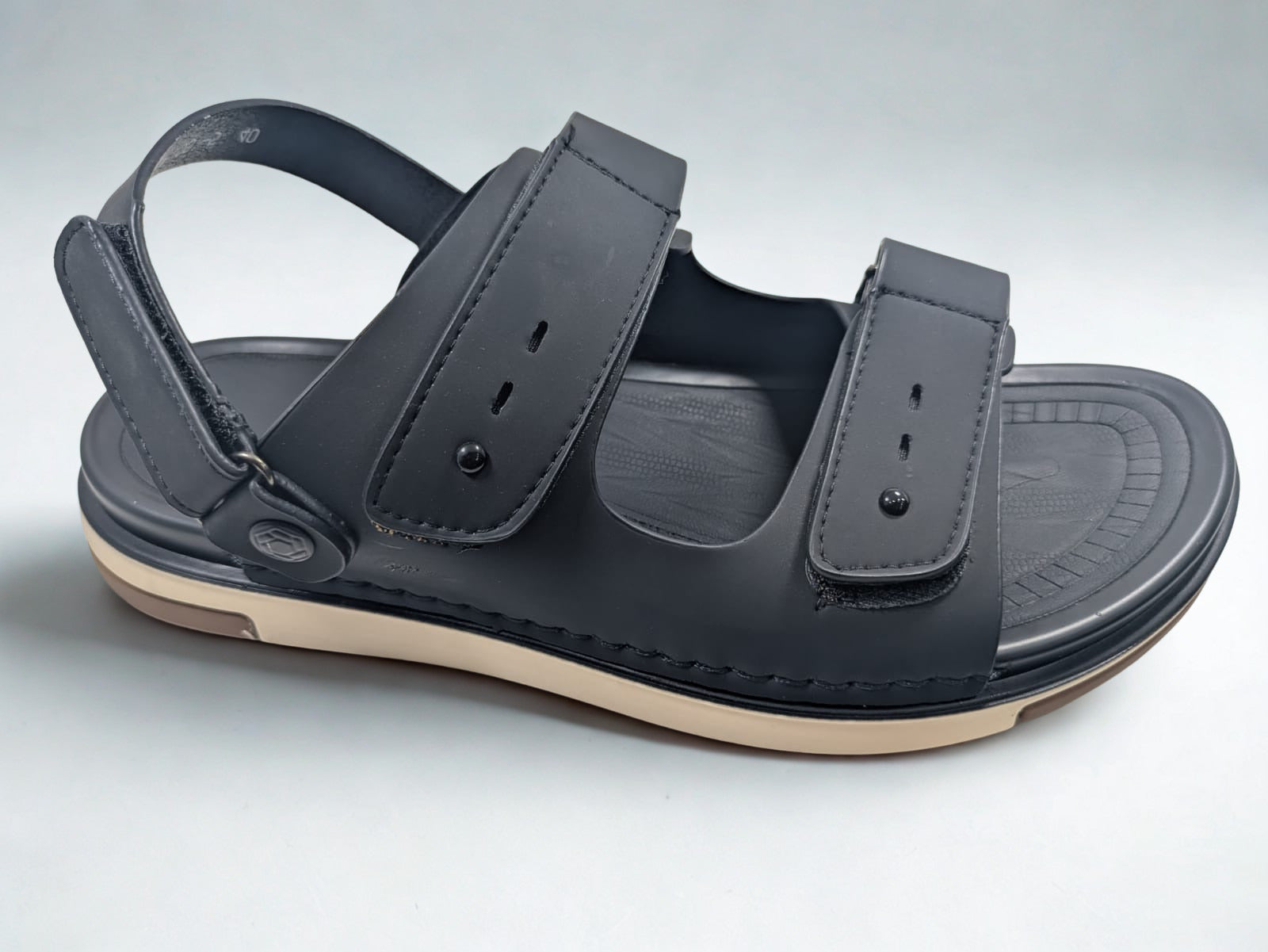 Black sandal with a strap on a light gray background