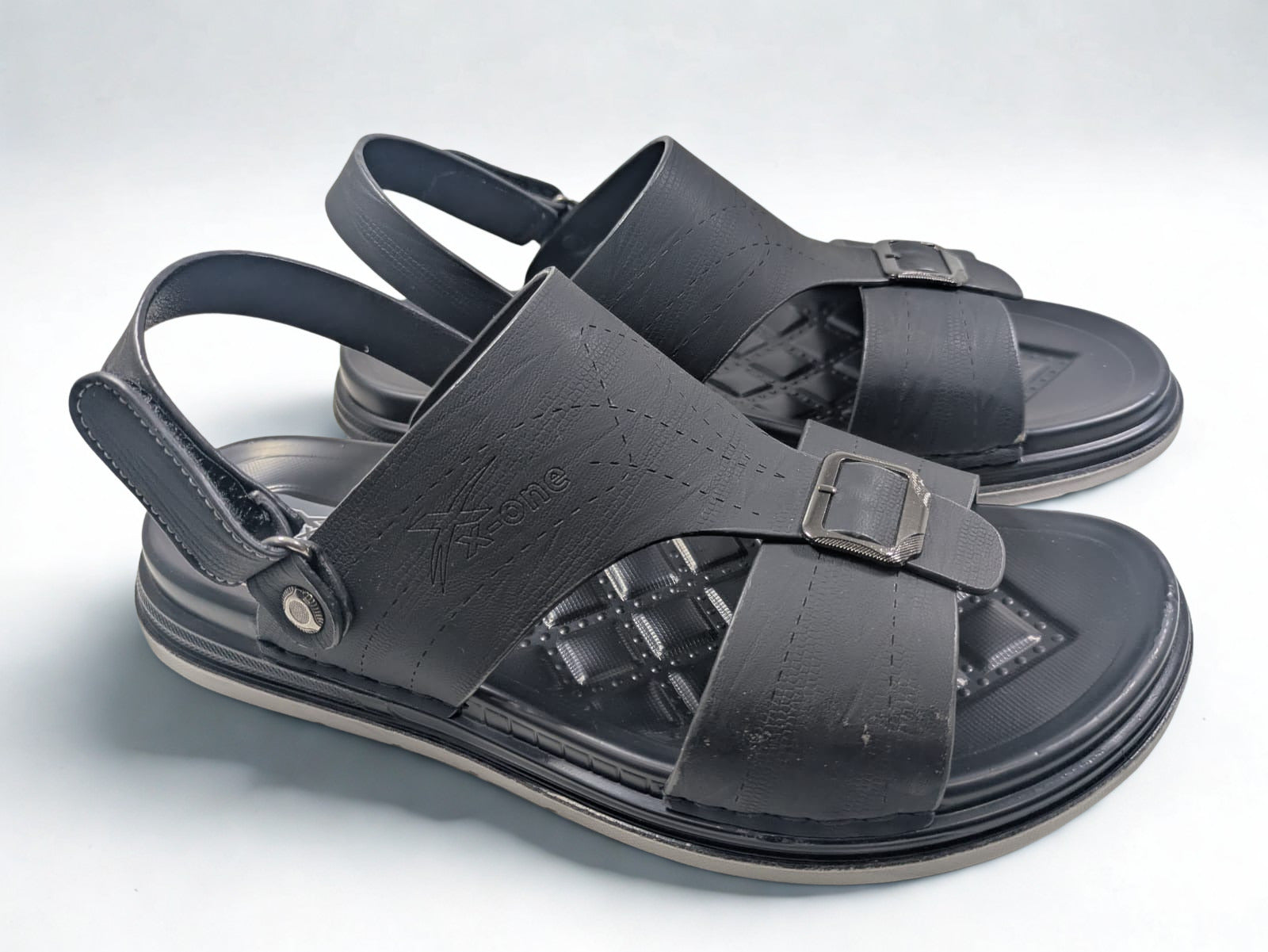 Black sandals with straps on a light gray background