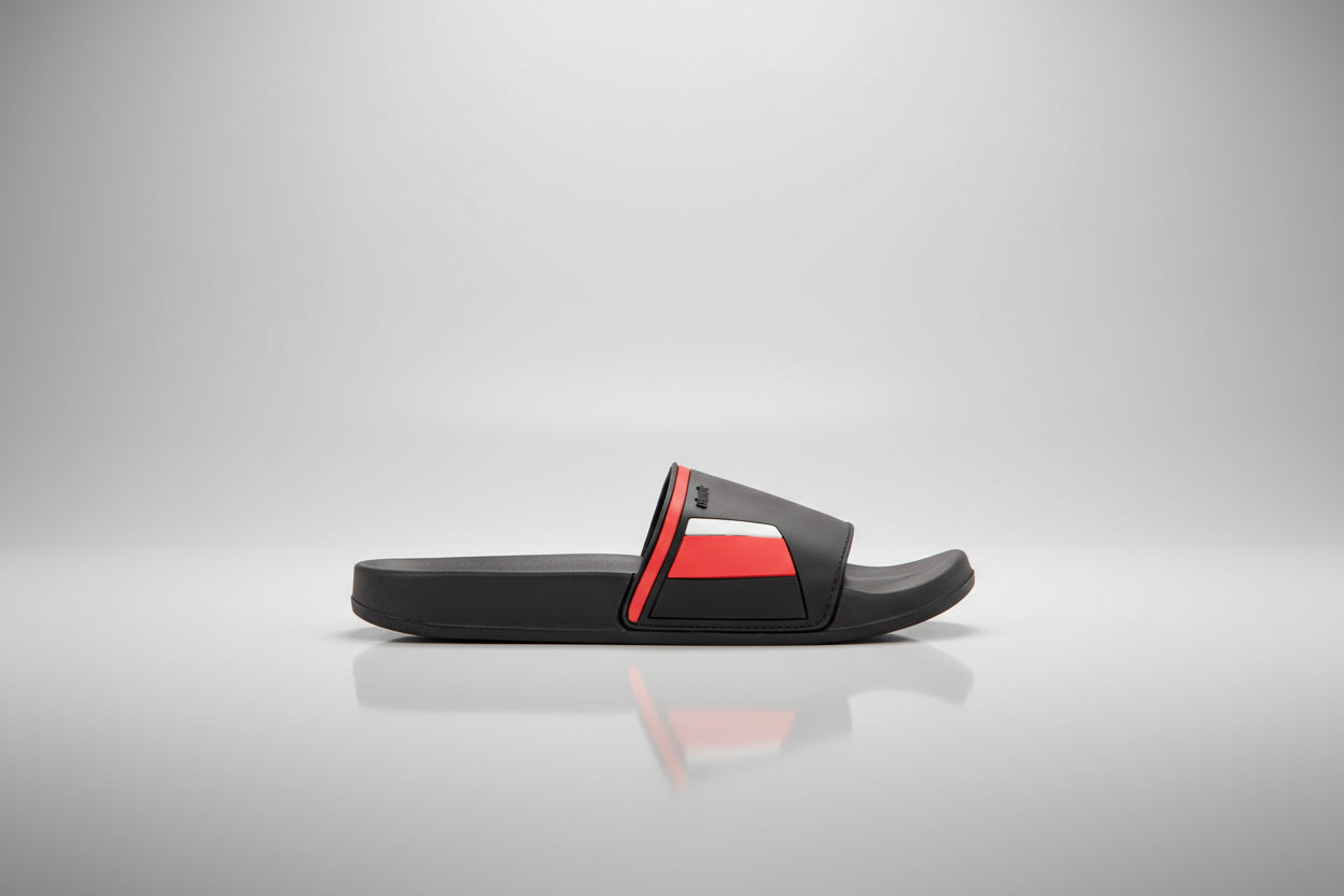 Black slide sandal with red accent on a white background
