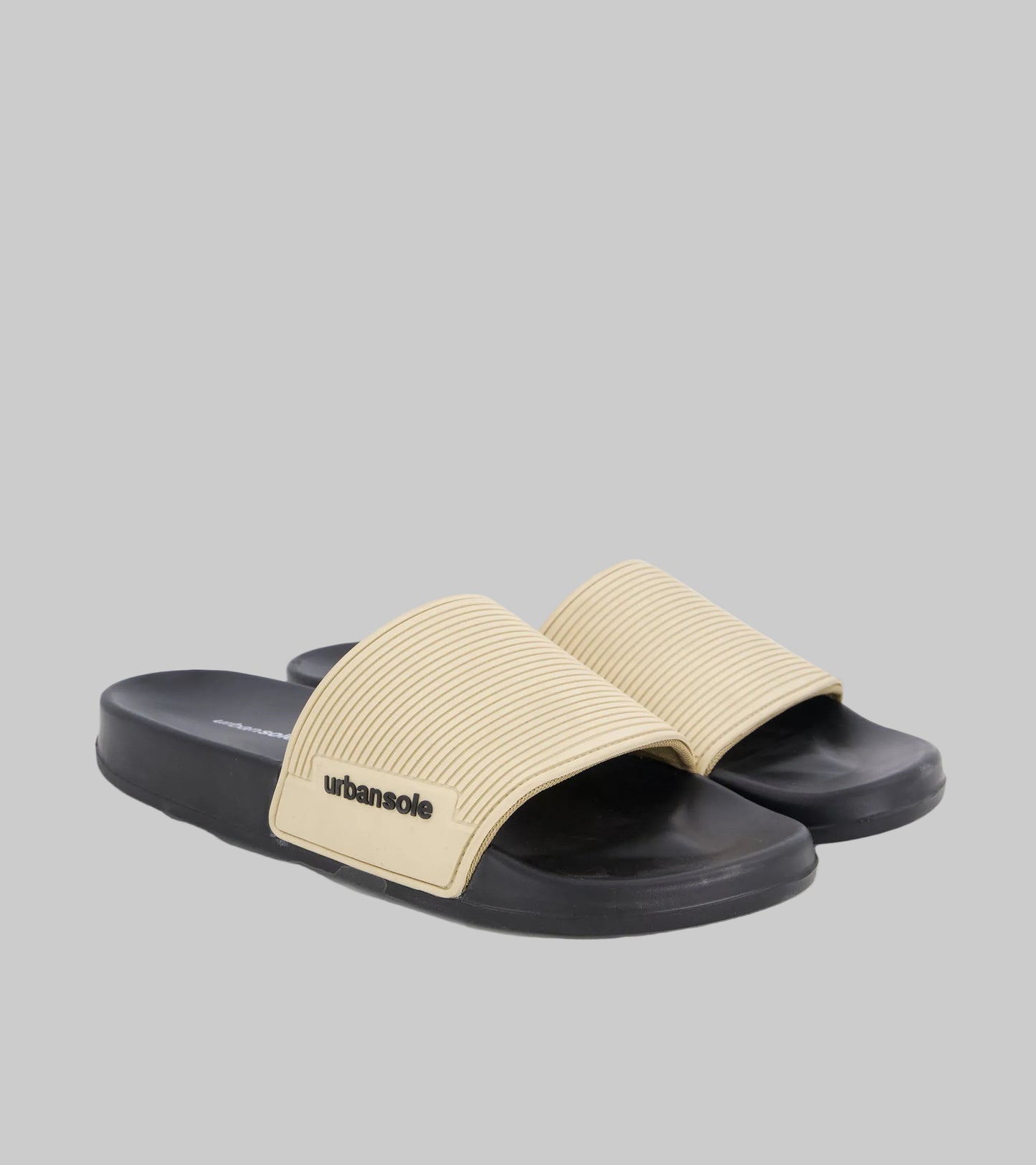 Beige and black slide sandals with 'urbansole' branding on a white background