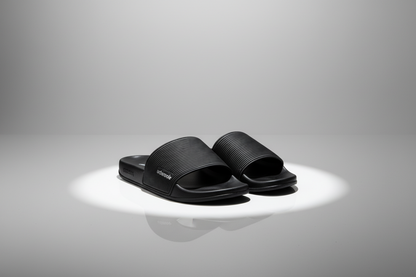 Black slides with ribbed straps on a white background