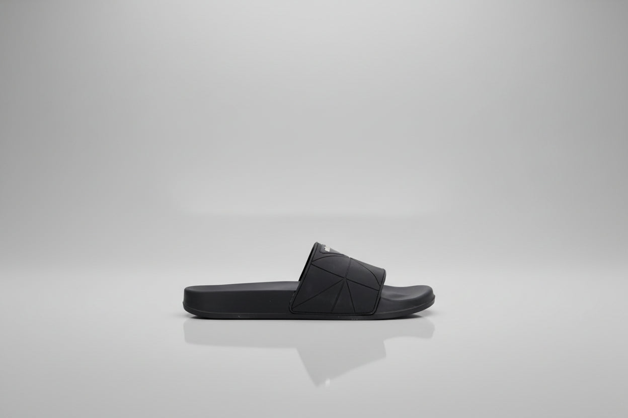 Black sandal with studded details on a white background