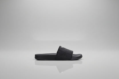 Black sandal with studded details on a white background