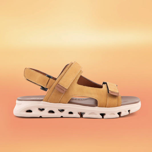 Tan sandal with a white sole on a light gray background