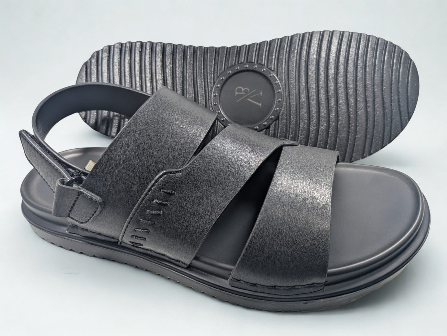 Black sandals with velcro straps on a light gray background