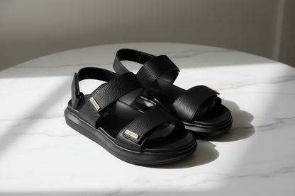 Black sandals on a white surface with a neutral background