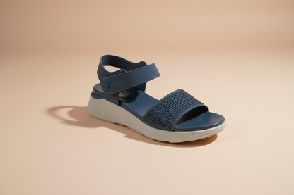 Navy blue sandal with white sole on a light gray floor