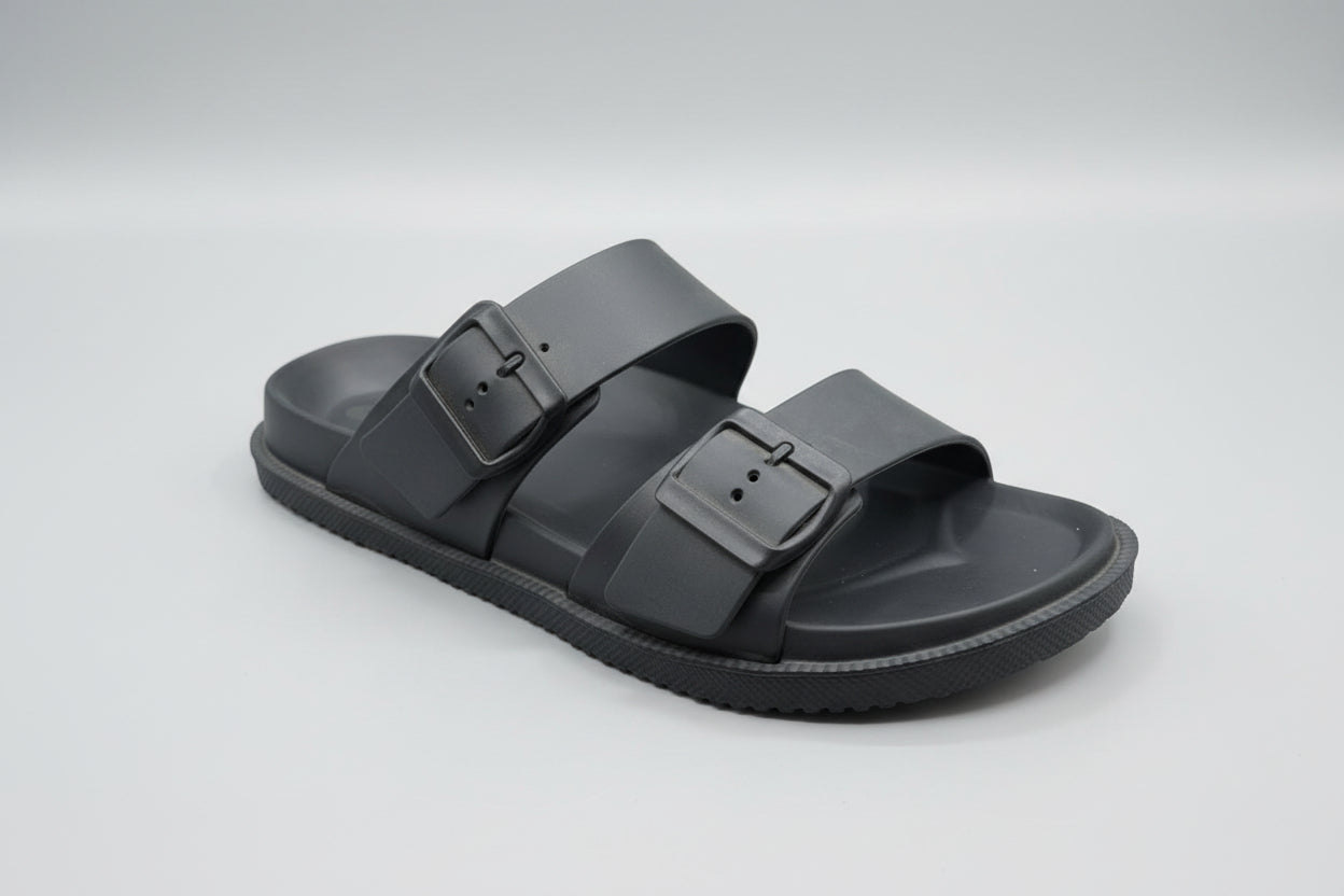 Black sandal with a buckle on a wooden surface