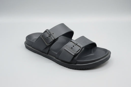 Black sandal with a buckle on a wooden surface