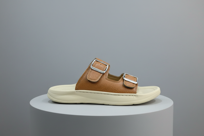 Brown sandal with silver buckles on a gray surface