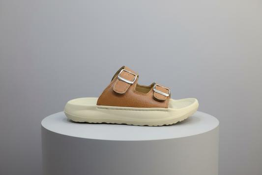 Brown sandal with two buckles on a wooden surface