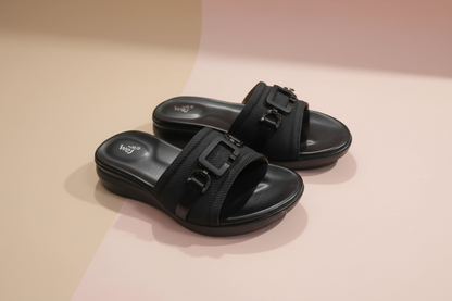 Black sandals with straps on a white tiled floor