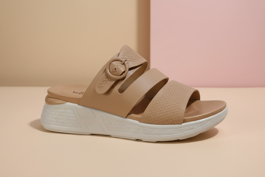 Tan sandal with a white sole on a tiled floor