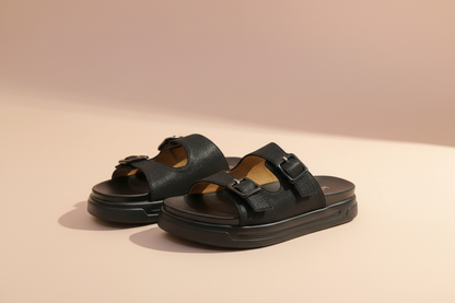 Black sandals with brown straps on a light-colored floor