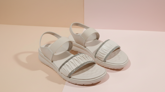 White sandals with decorative straps on a light background
