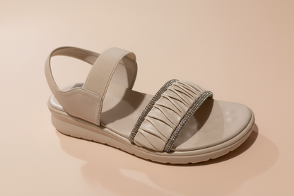 White sandal with decorative strap on a light background