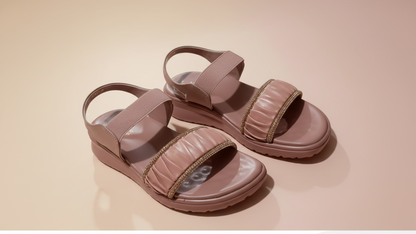 Pink sandals with gold embellishments on a light-colored floor.