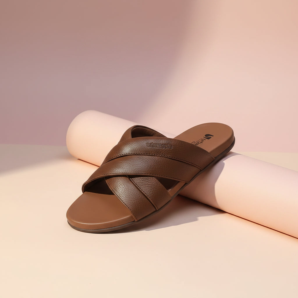 Pair of brown sandals with criss-cross straps on a white background