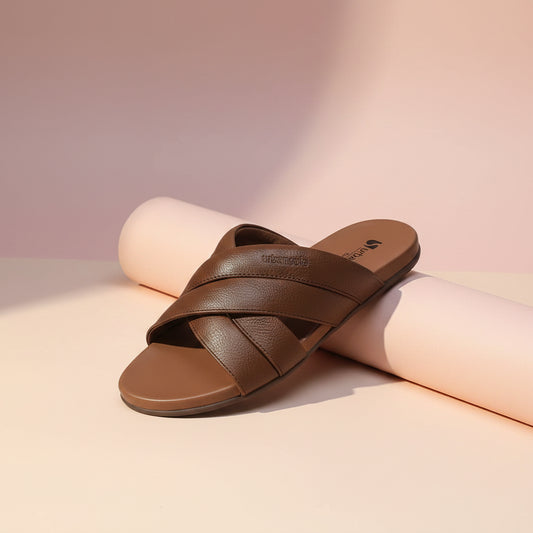 Pair of brown sandals with criss-cross straps on a white background