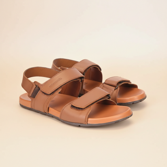 Pair of brown sandals on a light beige background