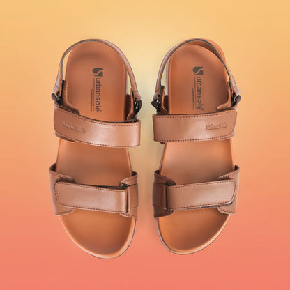 Pair of brown sandals with strap details on a white background